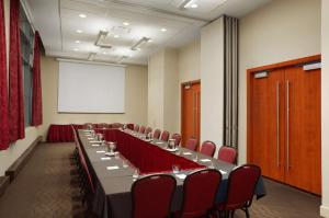 蒙特利尔蒙特利尔希尔顿合博套房酒店的一间会议室,配有长桌子和红色椅子