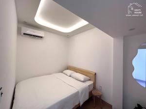 岘港Central, Minimalist and Cozy - Gau's House的卧室配有白色的床铺和白色的天花板