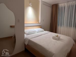 岘港Central, Minimalist and Cozy - Gau's House的一间卧室配有一张白色的床,上面装有盒子