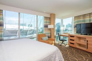 温哥华温哥华市中心汉普顿酒店的酒店客房配有一张床、一张书桌和一台电视。