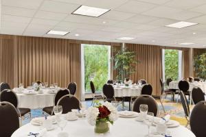温哥华温哥华市中心汉普顿酒店的一间会议室,里面配有桌椅和鲜花