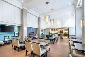 米西索加Hampton Inn & Suites by Hilton Toronto Airport的一间带桌椅和壁炉的用餐室