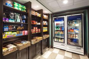 米西索加Hampton Inn & Suites by Hilton Toronto Airport的一间杂货店的过道,里面装有冰箱和食物