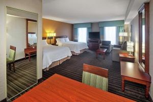 米西索加Hampton Inn & Suites by Hilton Toronto Airport的酒店客房设有床和客厅。
