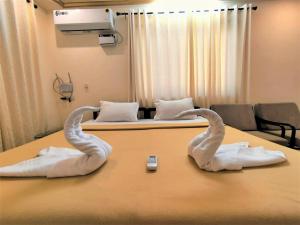 卡兰古特Shradha luxury room的医院房间桌子上两块毛巾天鹅