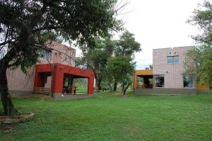 巴克罗斯Cabañas Mayma的绿色庭院旁的红色外墙建筑