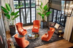 莱克兰The Terrace Hotel Lakeland, Tapestry Collection by Hilton的客厅配有橙色椅子和桌子