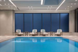多伦多Canopy By Hilton Toronto Yorkville的酒店客房带游泳池和椅子