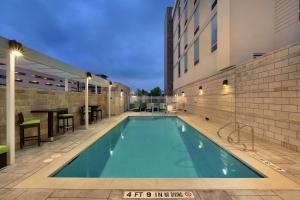 奥斯汀希尔顿Home2套房酒店 - 得克萨斯州奥斯汀北/靠近the Domain购物中心的建筑物一侧的游泳池