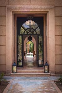 马拉喀什Villa Al Assala Palmeraie的进入带门和楼梯的大楼