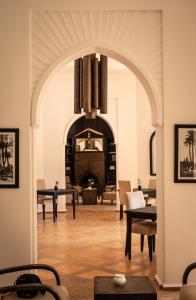马拉喀什Villa Al Assala Palmeraie的客厅设有带壁炉的拱门