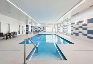 莱维斯魁北克市/圣罗幕德希尔顿恒庭酒店的蓝色和白色瓷砖的建筑中的游泳池