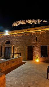 马尔丁Fairouz Konak Otel的一座带灯光的大型石头建筑