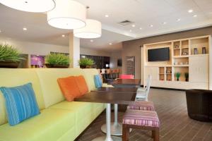 夏洛特夏洛特机场希尔顿欣庭套房酒店的一间配有沙发和桌椅的等候室
