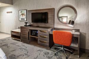 弗雷斯诺Hampton Inn Fresno Airport的酒店客房配有带电视和镜子的书桌