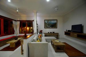 Tirtagangga三泰卡朗阿森别墅旅馆的带沙发和电视的客厅