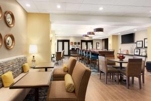 肯纳威克Hampton Inn by Hilton Kennewick at Southridge的一间带桌椅的餐厅和一间酒吧