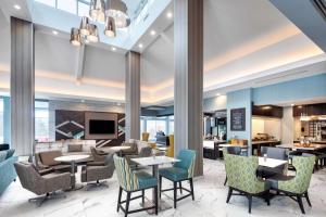 恩菲尔德哈利法克斯机场希尔顿花园酒店的一个带桌椅的大堂和一间餐厅