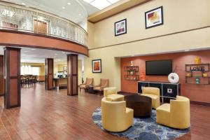 米德韦斯特城Hampton by Hilton Oklahoma City I-40 East- Tinker AFB的大堂设有等候区,配有电视和椅子