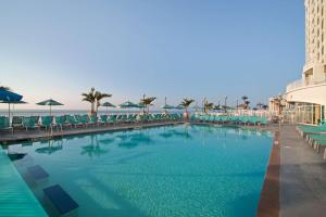大洋城海滩城市希尔顿套房酒店的一座带椅子的大型游泳池和一座建筑