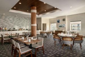 大洋城海滩城市希尔顿套房酒店的一间带桌椅的餐厅和一间酒吧