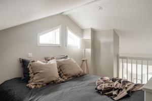 奥萨Modern nybyggd lägenhet i Orsa Grönklitt的白色卧室配有带枕头的床