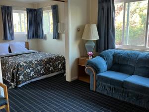 西雅图马可波罗汽车旅馆的酒店客房,配有床和蓝色的沙发