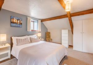SwimbridgeDairy Cottage的卧室配有白色的床和窗户。