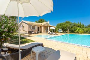罗达Villa Popi的一座带游泳池和遮阳伞的别墅