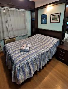 阿雷格里港Apartamento Completo 2 Quartos Wi-Fi 300 Mbps的一间卧室配有一张床,并备有拖鞋