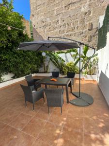 马略卡岛帕尔马Casa de Limon的露台的遮阳伞下的桌椅