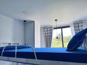 芽庄I Play Inn NT的一间卧室设有蓝色的床和窗户。