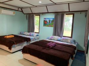 Siboya拉查日落度假酒店的配有两张床铺的蓝色墙壁和窗户