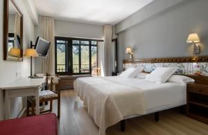 坎丹奇奥坎丹丘雪绒花酒店的酒店客房设有一张大床和一张书桌。