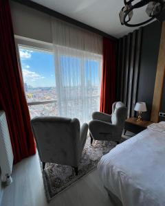 伊斯坦布尔ZamZam Suites Istanbul的酒店客房设有床、椅子和大窗户。