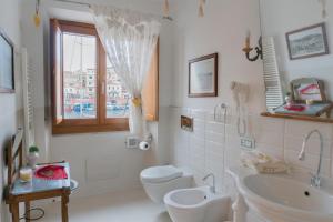 马达莱纳摩尔蒂尼酒店的一间带卫生间、水槽和窗户的浴室
