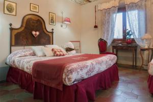 马达莱纳摩尔蒂尼酒店的一间卧室配有一张带红色毯子的大床