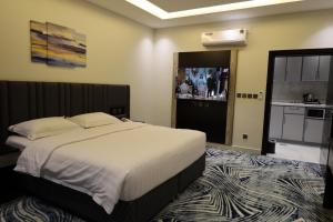 Al Namasقمم بارك Qimam Park Hotel 6的一间带大床的卧室和一间厨房