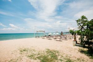 金巴兰Donguri House Bali的海滩上设有桌椅,大海上设有沙滩