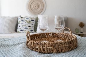 圣胡安OCEAN VIEW DELUXE SUITE: PVT. BEACH & POOL的床上的两杯酒和一篮子