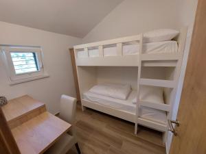 KomenGostilna in pizzeria Pri Brajdi的客房设有带白色双层床的双层床。