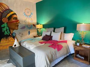 埃斯孔迪多港Casa Conicarit的卧室配有一张带女性绘画的床