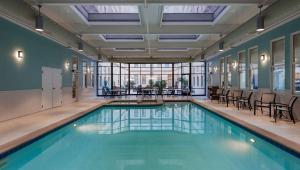里士满里士满市中心希尔顿酒店的大楼内一个带桌椅的游泳池