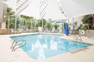 亨里埃塔罗切斯特希尔顿逸林酒店的一座配有桌椅的酒店游泳池