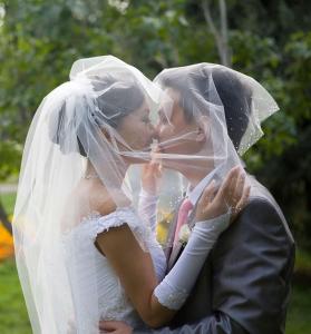 布卢明顿布卢明顿希尔顿惠庭套房酒店的戴着面纱的新娘和新娘亲吻