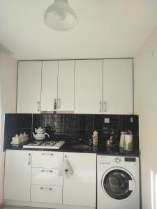 特拉布宗Hamsiköy Merkez Daire的厨房配有白色橱柜和洗衣机。