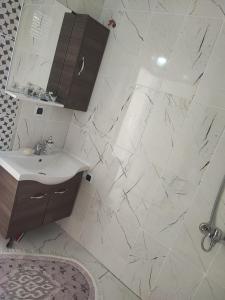特拉布宗Hamsiköy Merkez Daire的白色瓷砖浴室设有水槽和镜子