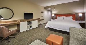 罗斯堡Hampton Inn & Suites Roseburg的酒店客房,配有床和电视