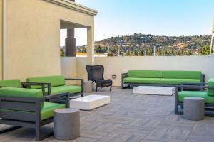 贝尔蒙Homewood Suites By Hilton Belmont的一个带绿色沙发和椅子的屋顶露台