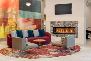 贝尔蒙Homewood Suites By Hilton Belmont的客厅配有沙发、两把椅子和壁炉